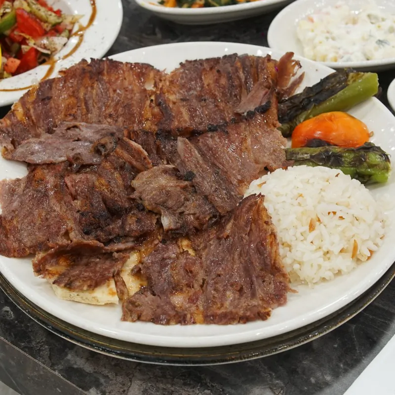 Tabakta pilav üstü döner, közlenmiş biber ve domates