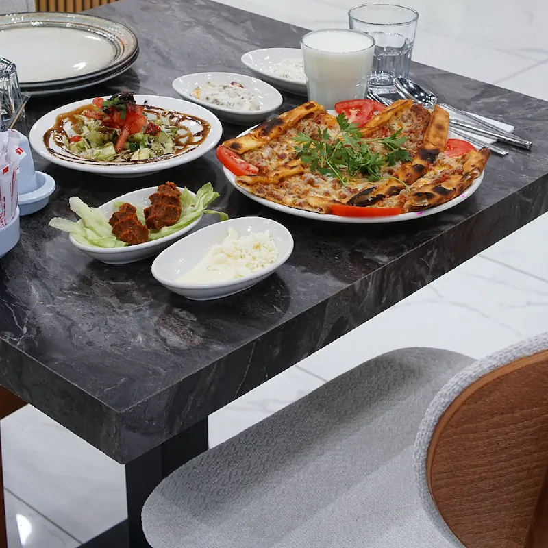 Pide, salata, meze, çiğ köfte ve ayranla kurulmuş masa